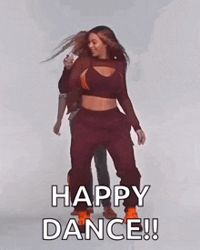 a woman in a crop top and sweatpants is dancing with a man behind her and the words happy dance !