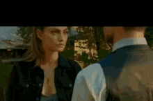 a man and a woman are looking into each other 's eyes . the man is wearing a suit and tie .