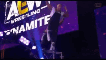 a man is jumping in front of a sign that says dynamite wrestling