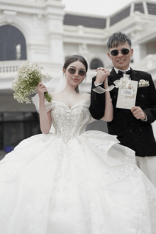a bride and groom holding hands while the bride holds a bouquet of flowers