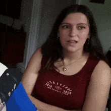a woman wearing a red tank top that says ' oceanside ' on it