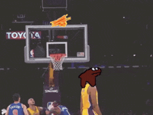 a basketball player wearing a yellow lakers jersey stands in front of a basketball hoop