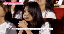 a girl is crying while sitting in a theatre with a sign that says b14 on it