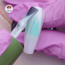 a brush is being used to paint a nail with a pink glove behind it that says nails inspiration
