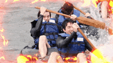 a group of people in life jackets are rowing a raft in a river
