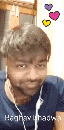 a man wearing ear buds and the name raghav bhadra on his shirt