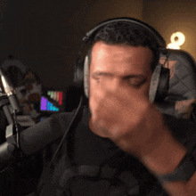 a man wearing headphones and a black shirt with a star wars logo