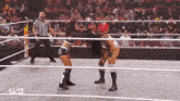 two women are wrestling in a wrestling ring while a referee looks on .