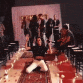 a woman is kneeling on the floor in front of a group of people with balloons in the background that say congratulations