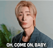 a young man says oh come on baby in front of a plant