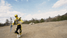 a man in a yellow and black superhero costume is holding a sword