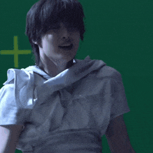 a man in a white shirt is laughing in front of a green screen