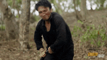 a man in a black shirt is holding a knife in the woods with the words shadow force on the bottom