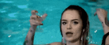 two women are dancing in a pool with their arms outstretched .