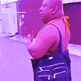 a man wearing a tank top and carrying a bag with the letter f on it