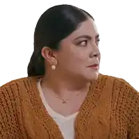 a woman wearing a brown sweater and pearl earrings looks to the left