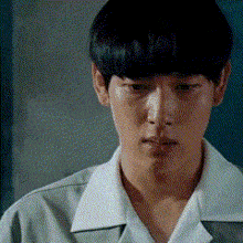a close up of a young man wearing a white shirt and a grey jacket .
