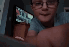 a boy wearing glasses is looking at a tv screen that says mlb on it