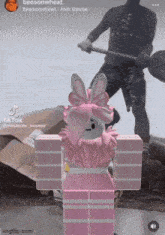 a girl in a pink outfit with bunny ears is standing in front of a man holding a shovel