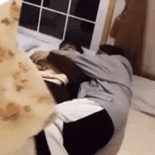 two people are laying on a bed and one is holding the other 's arm .
