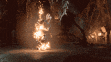 a person is surrounded by fire in a dark room with a monster in the background