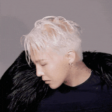 a man with a tattoo on his neck is wearing a black shirt and a black fur coat