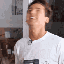 a man wearing a white atari t-shirt is smiling