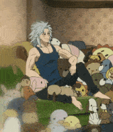 a man sitting on a couch surrounded by stuffed animals