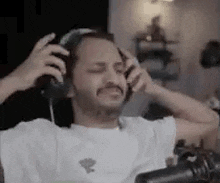 a man is sitting in front of a microphone wearing headphones .