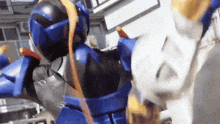 a blue robot is fighting a white robot in a city .