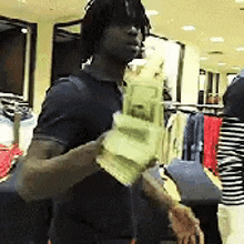 a man is holding a bunch of money in his hand in a store