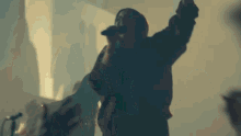 a person is singing into a microphone with their hands in the air