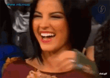 a close up of a woman laughing with the website www.ntcmusic visible in the corner