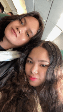two girls sitting next to each other on a plane