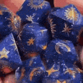 a close up of a person holding a pile of blue dice with gold stars on them .