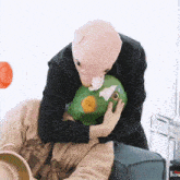 a person wearing a pig mask is holding a green frog