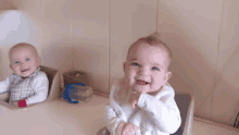 two babies are sitting next to each other and one has a bottle that says ' nuby ' on the handle