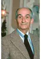 a man wearing a plaid suit and tie smiles for the camera