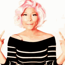 a woman with pink hair and a black and white striped shirt is giving the middle finger