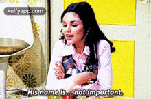 a woman is sitting at a table with her arms crossed and saying her name is not important .