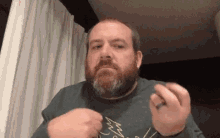 a man with a beard is wearing a green sweater with a christmas tree embroidered on it .