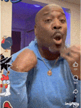 a man wearing a blue shirt and a gold necklace