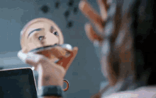 a woman applies makeup in front of a mirror