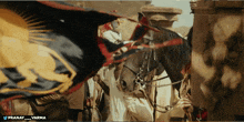 a banner with a lion on it is being held by a man standing next to a horse