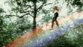 a person is standing in the middle of a forest with a rainbow in the background .