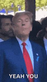 a man in a suit and tie is making a funny face and says yeah you .