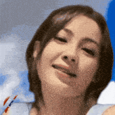 a close up of a woman 's face with a red white and blue ribbon around her neck