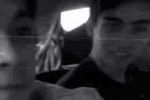 a black and white photo of a man taking a selfie .