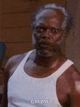 a man with a beard and mustache is wearing a white tank top .