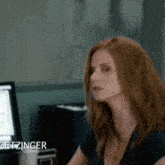 a woman is sitting in front of a computer with the name getzinger on the bottom right